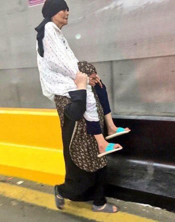 سيدة مصرية تحمل والدتها العجوز على كتفها لتوصيلها للكعبة المشرفة